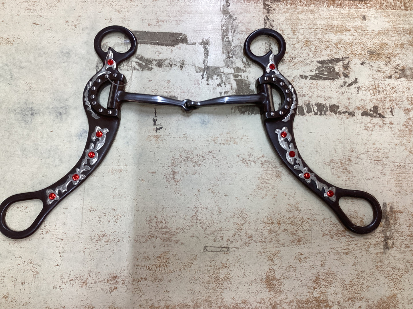 Locked broken snaffle bit with floral and colored gems on shanks